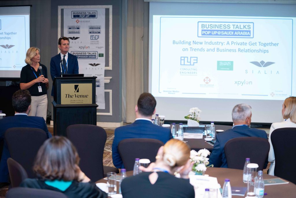 Speakers presenting at Business Talks Pop Up Saudi Arabia, a private event focused on trends and business relationships, with attendees seated in a conference room.